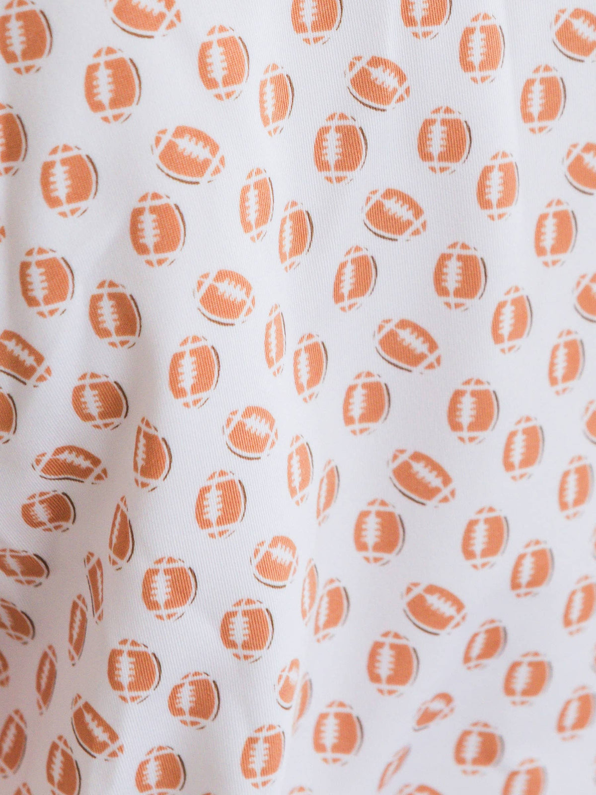 Pattern of orange footballs on a white background