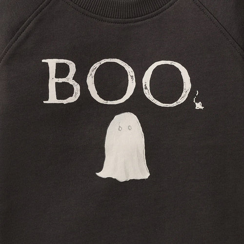 Close-up of a black toddler organic sweatshirt featuring a white distressed graphic that reads 'BOO' above a simple ghost illustration
