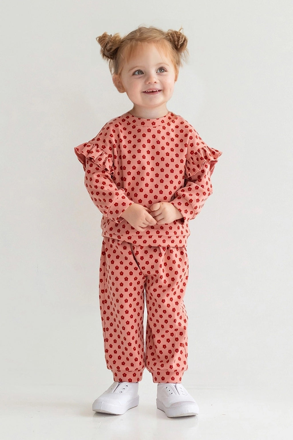 Child wearing a red polka dot outfit on a white background