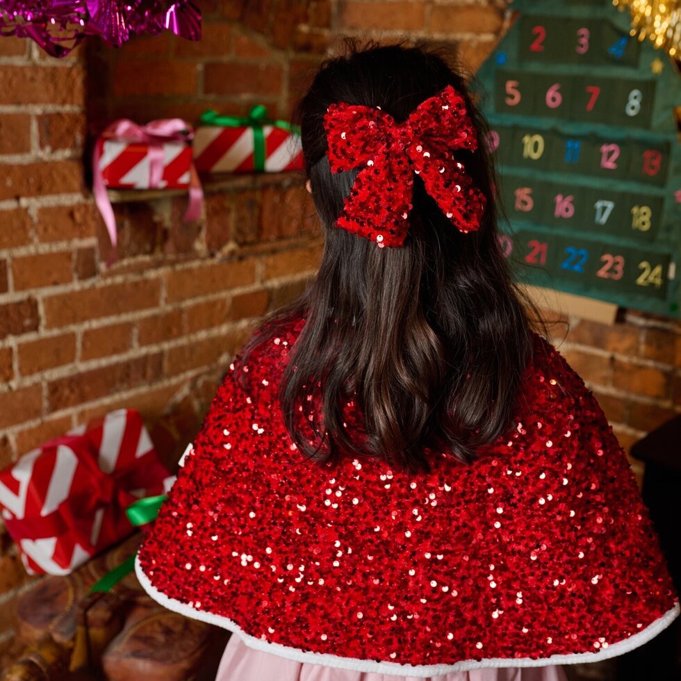 young girl wearing red sequin bow on hair